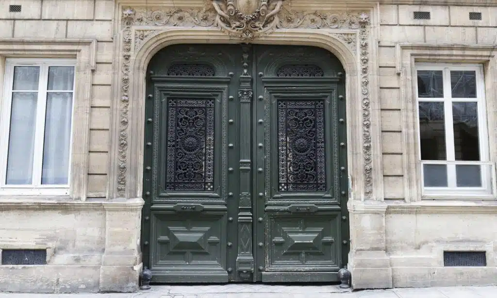 Imposante porte d'entrée en bois d'une immeuble haussmannien à Paris