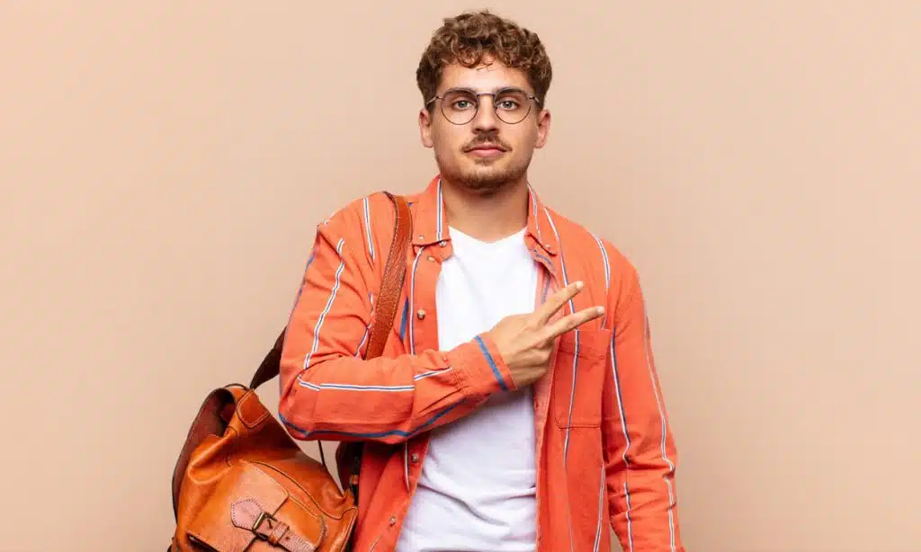 Un étudiant qui fait le signe de la victoire avec ses doigts