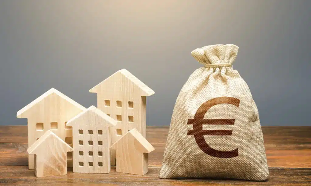 Maquettes de maison en bois à coté d'un sac d'argent