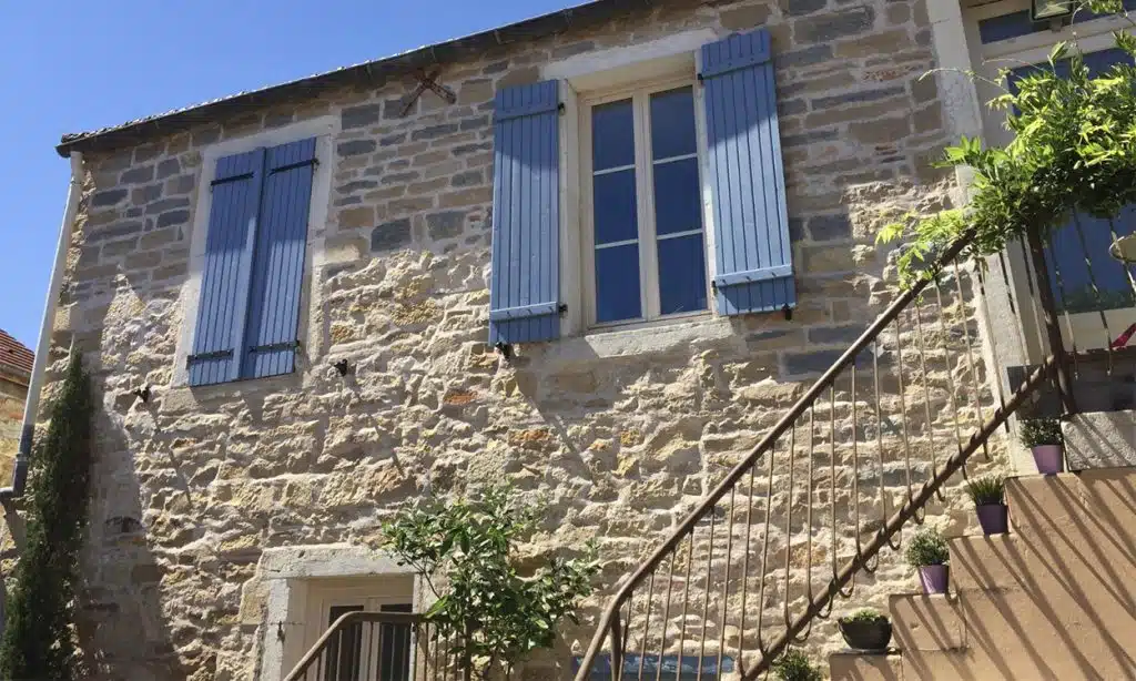 Belle maison en pierre avec des volet bleus