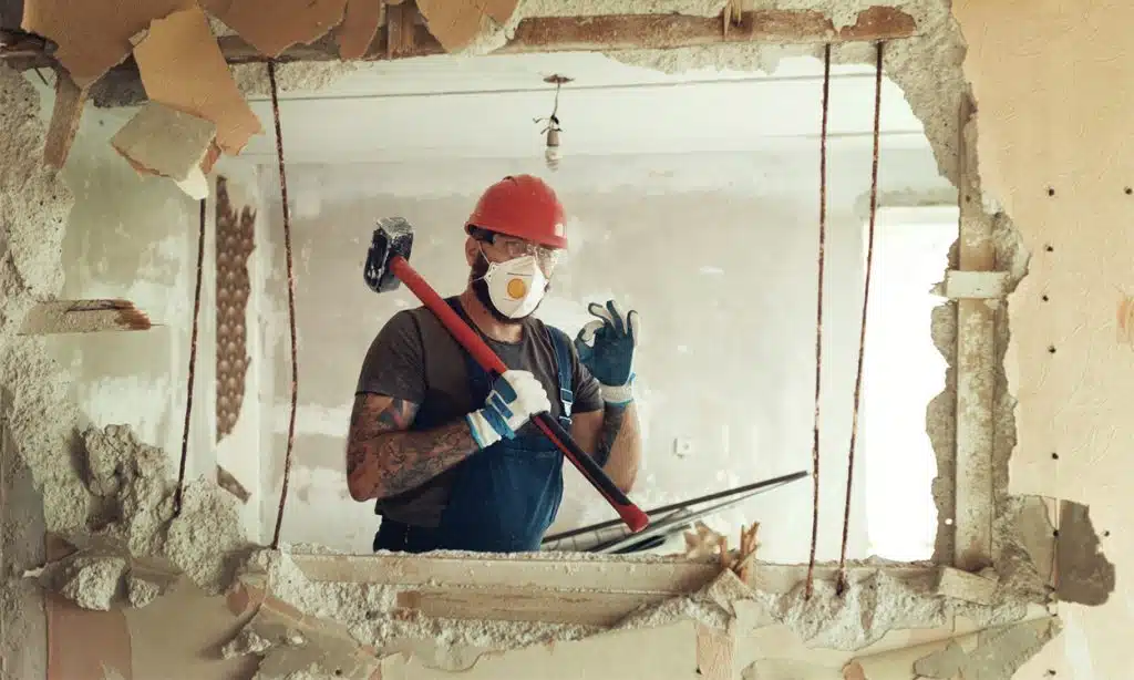 Un artisan qui démoli un mur intérieur