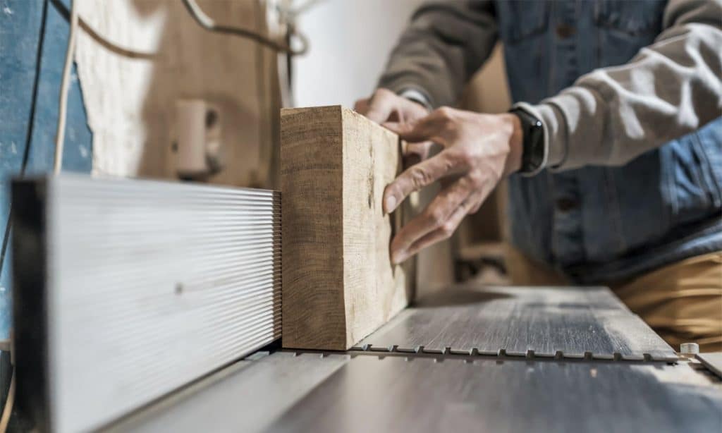 Un charpentier qui taille une planche en bois