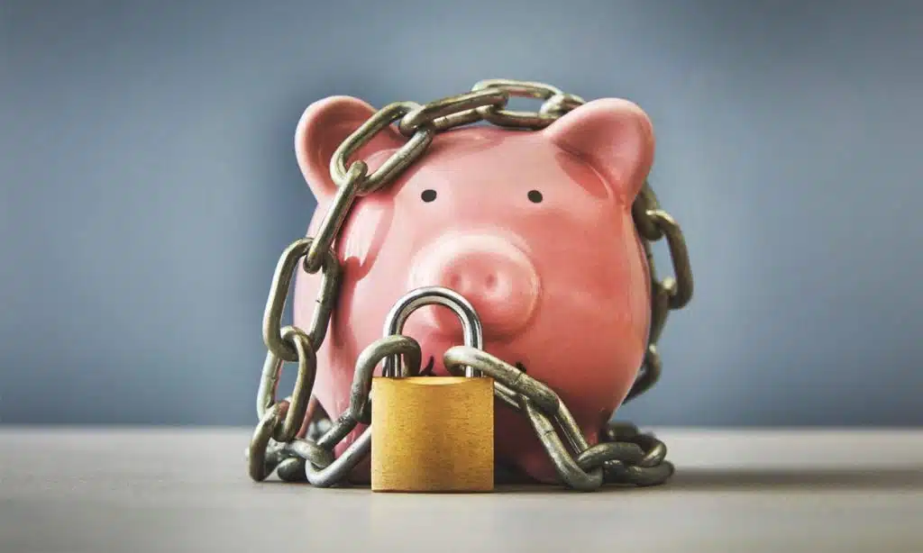 Tirelire cochon entourée par des chaînes et un cadenas