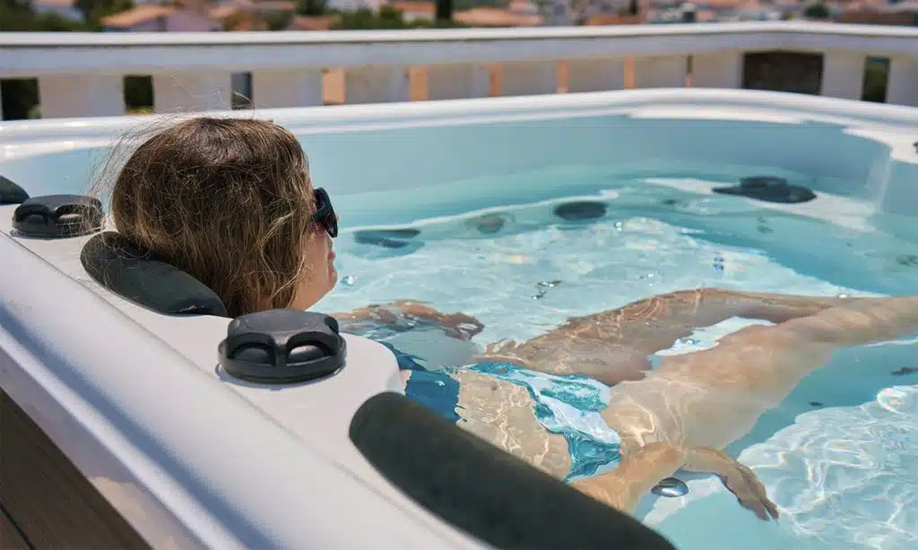 Une femme qui profite de son jacuzzi extérieur