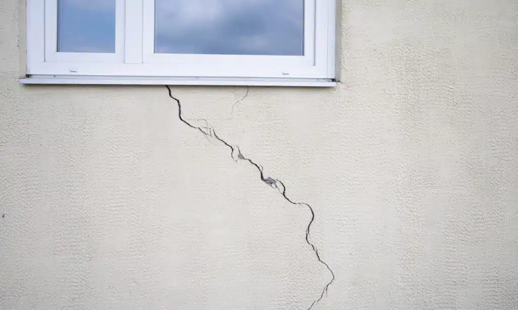 Grosse fissure sur le mur sous la fenêtre d'une maison individuelle