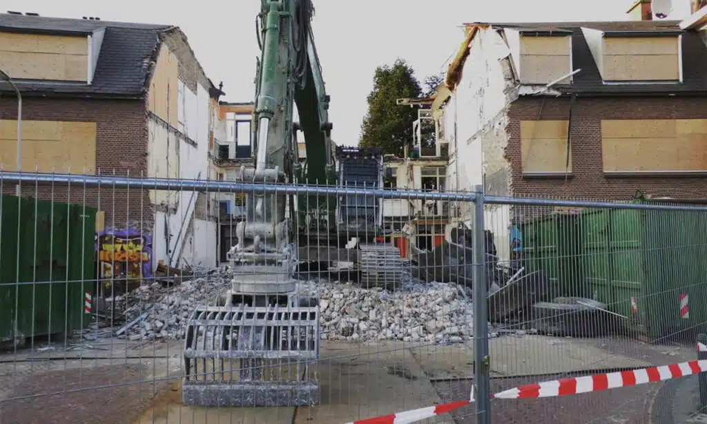 Démolition d'un immeuble de rapport avec une pelle