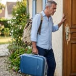 Propriétaire inquiet découvrant la serrure forcée de sa maison à son retour de vacances