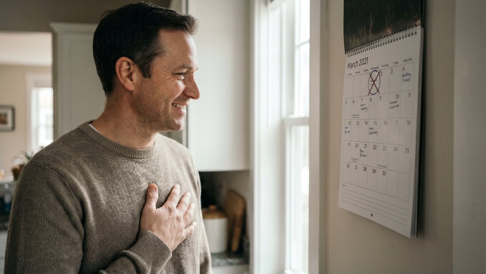 Homme soulagé devant un calendrier, sans date limite pour changer d'assurance emprunteur