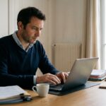 Un proprietaire bailleur gere ses factures sur ordinateur portable, facturation electronique en location meublee