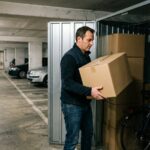 Un homme dépose un carton dans un box de stockage aménagé dans le parking souterrain d'un immeuble d'habitation