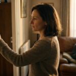 Une femme regle le thermostat de son salon, un adolescent lit sur le canape