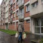 Locataire devant un immeuble de logement social HLM