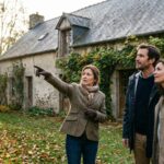 Agent immobilier presentant une maison ancienne a des acheteurs, marche immobilier 2026